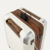 Close-up of a cream white suitcase with USB cable outlet on a white background.