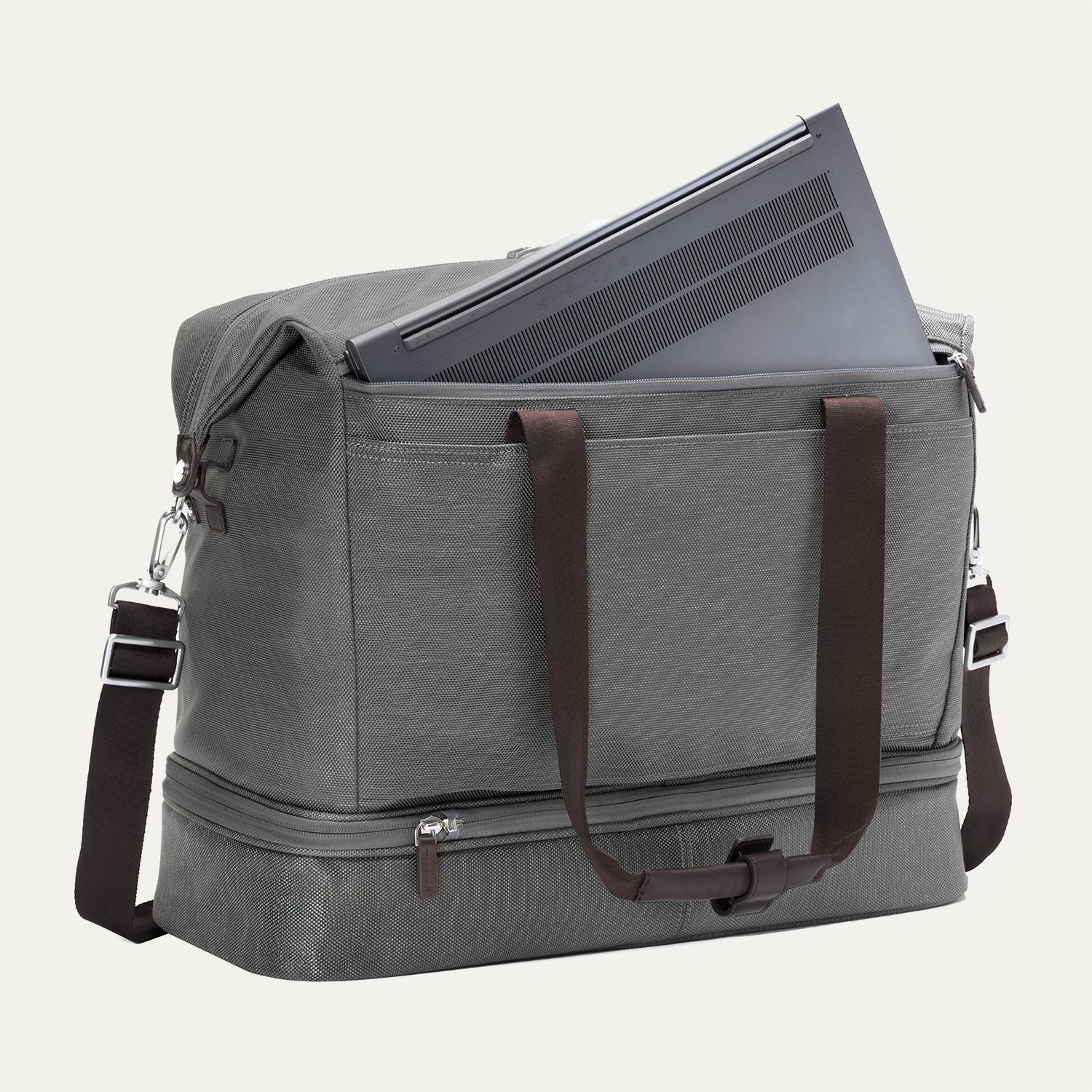 Grey weekender with a laptop shown in the interior padded sleeve compartment on white background