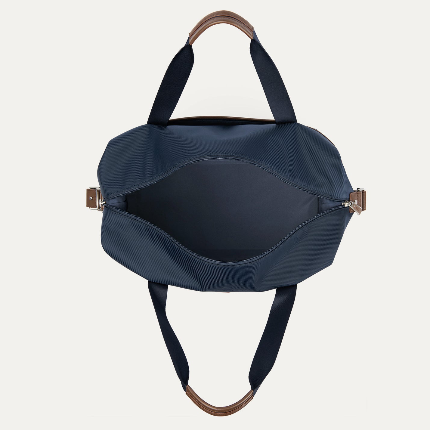 Blue handbag with brown handles and zippers on a white background