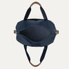 Blue handbag with brown handles and zippers on a white background