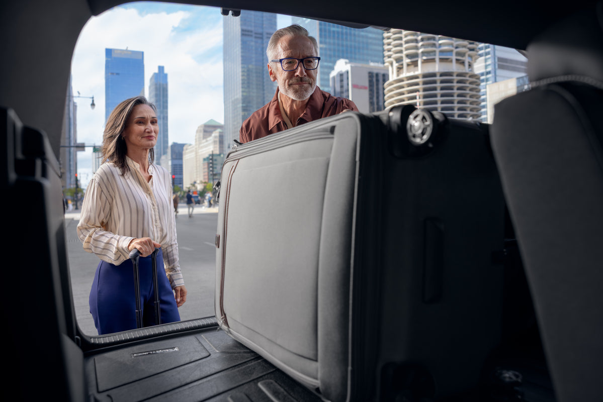 Man and woman putting luggage in a car