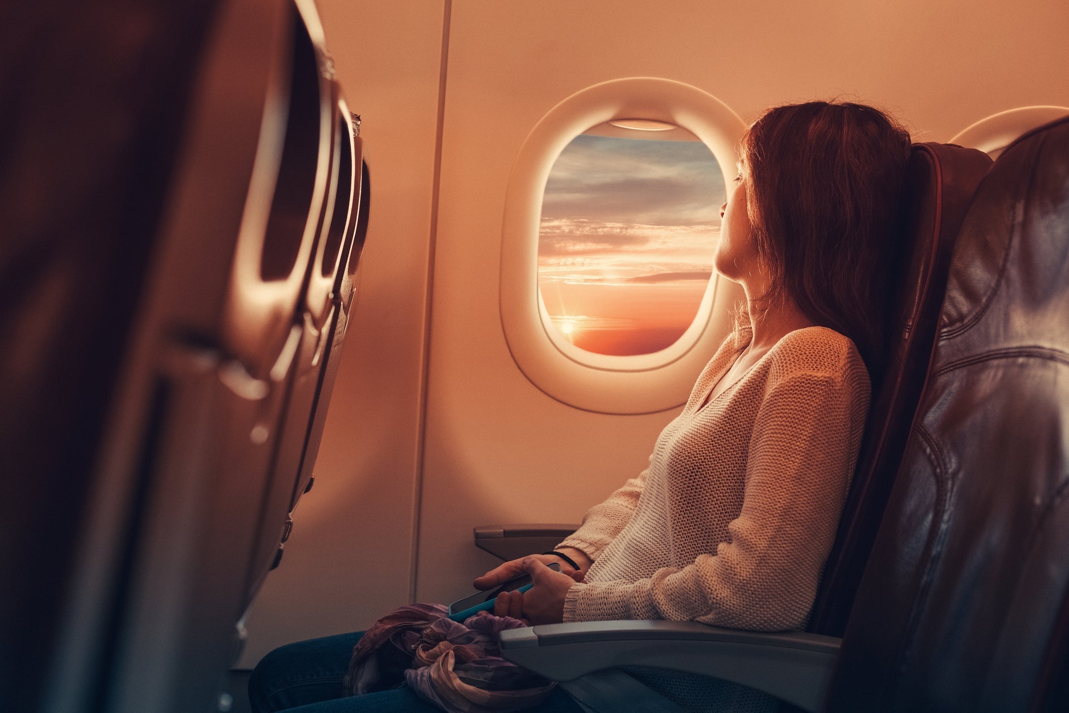 woman sitting on plane looking out of a window