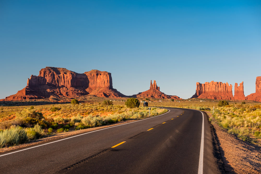 open highway with canyons in the background 