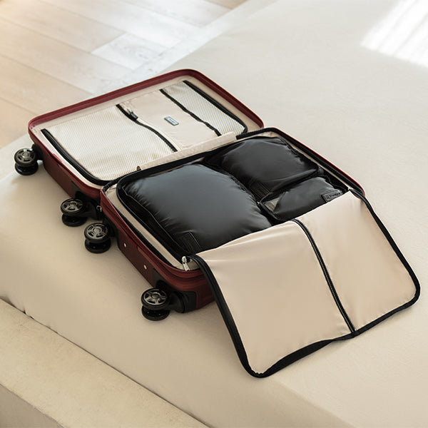 Open suitcase with packing cubes on a bed