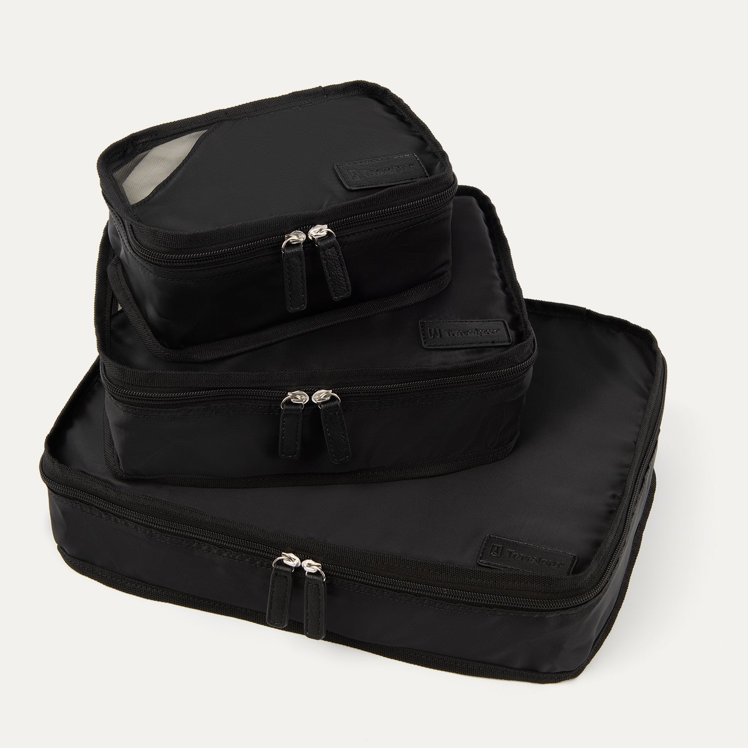 A set of three black Travelpross packing cubes, with the largest at the bottom, medium in the middle, and the smallest at the top, all with zipper closures.