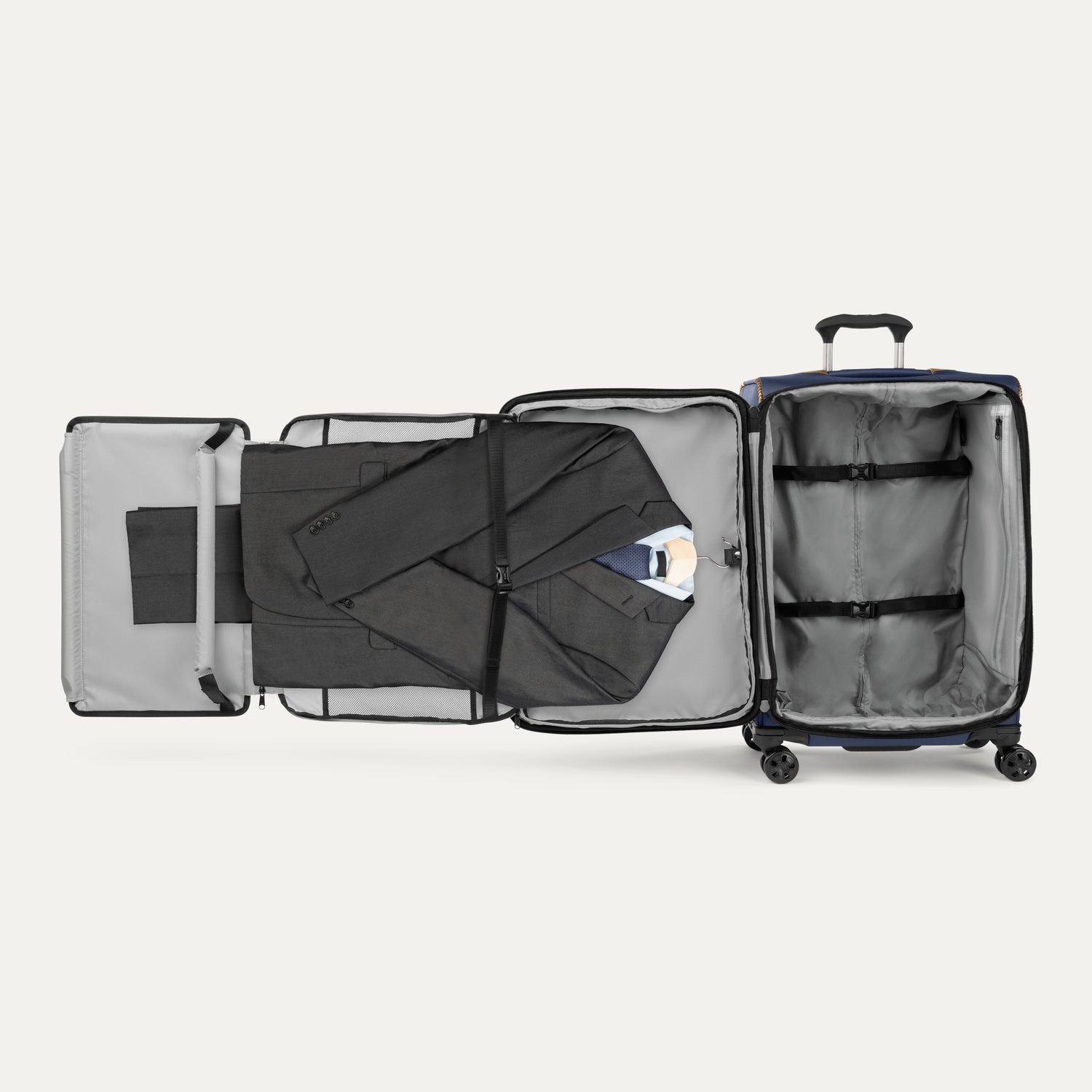 Open suitcase with suit displayed in fold out suiter compartment on white background
