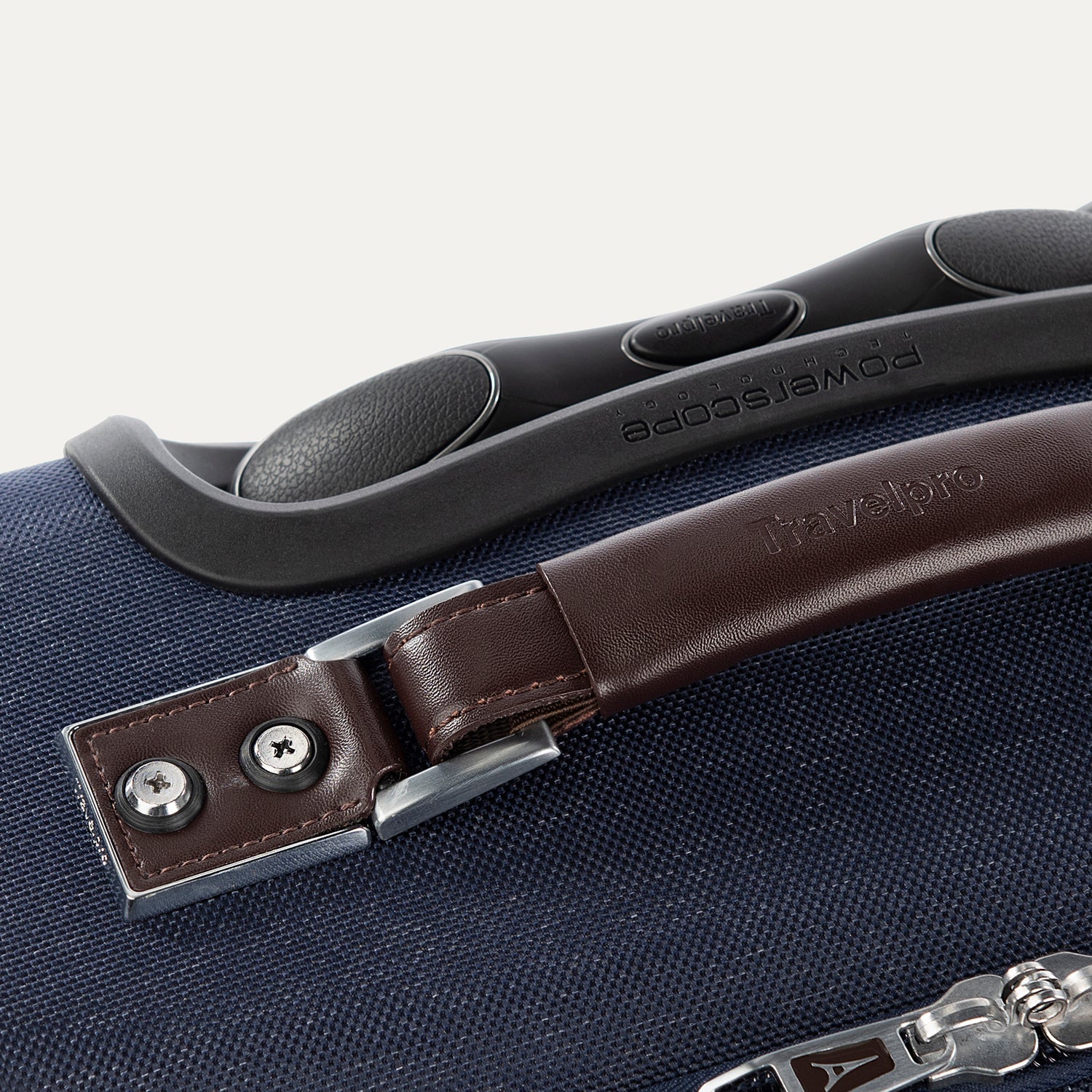 Close-up of a suitcase handle with a brown leather strap and silver hardware on a blue suitcase.