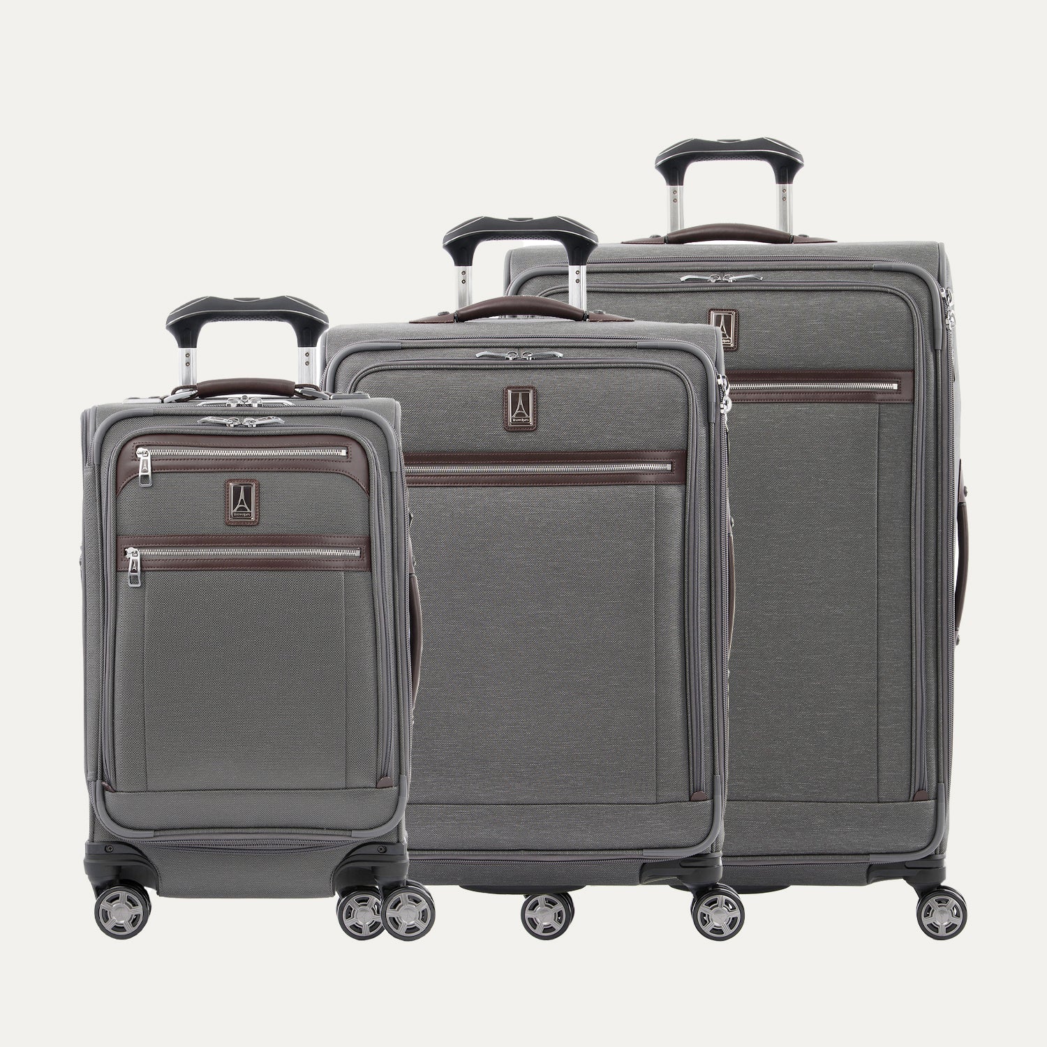 A set of three grey Platinum Elite spinner luggage bags, including a carry-on size and two larger sizes, with chrome zippers and leather accents.