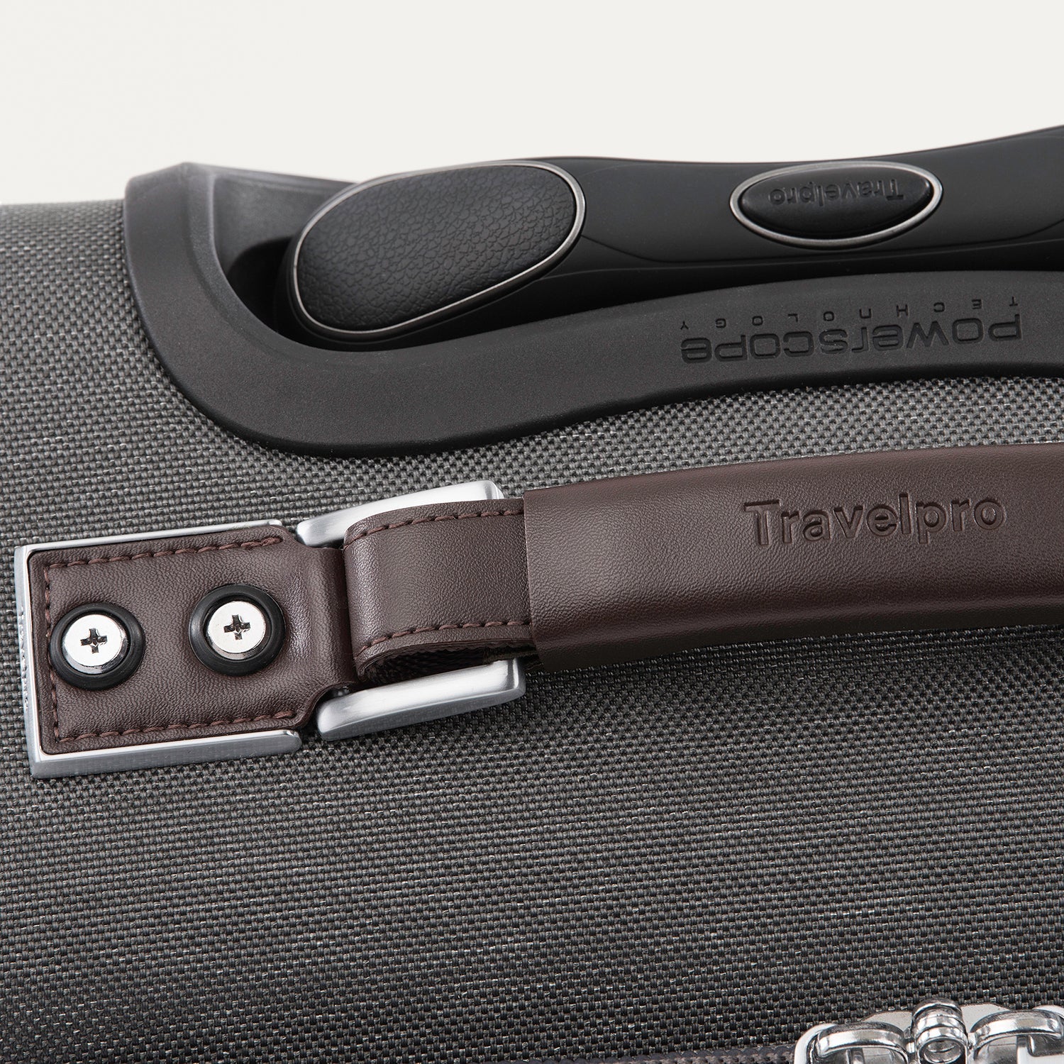 Close-up of a suitcase handle with a brown leather strap 
