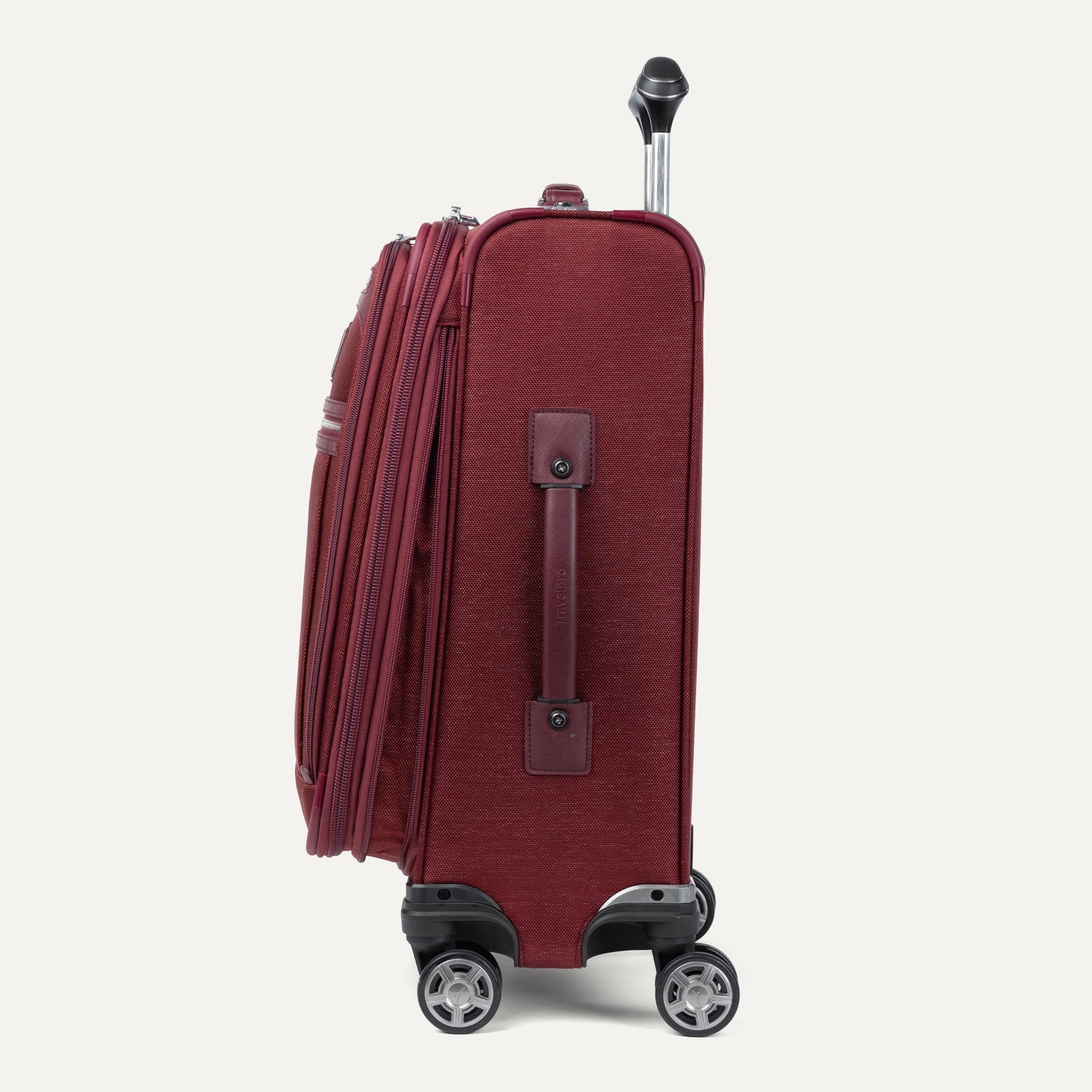 Side view of expanded red suitcase with wheels and handle on a white background