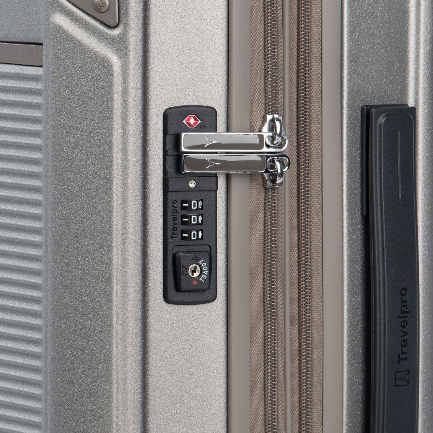 Close-up of a suitcase lock on a silver suitcase.