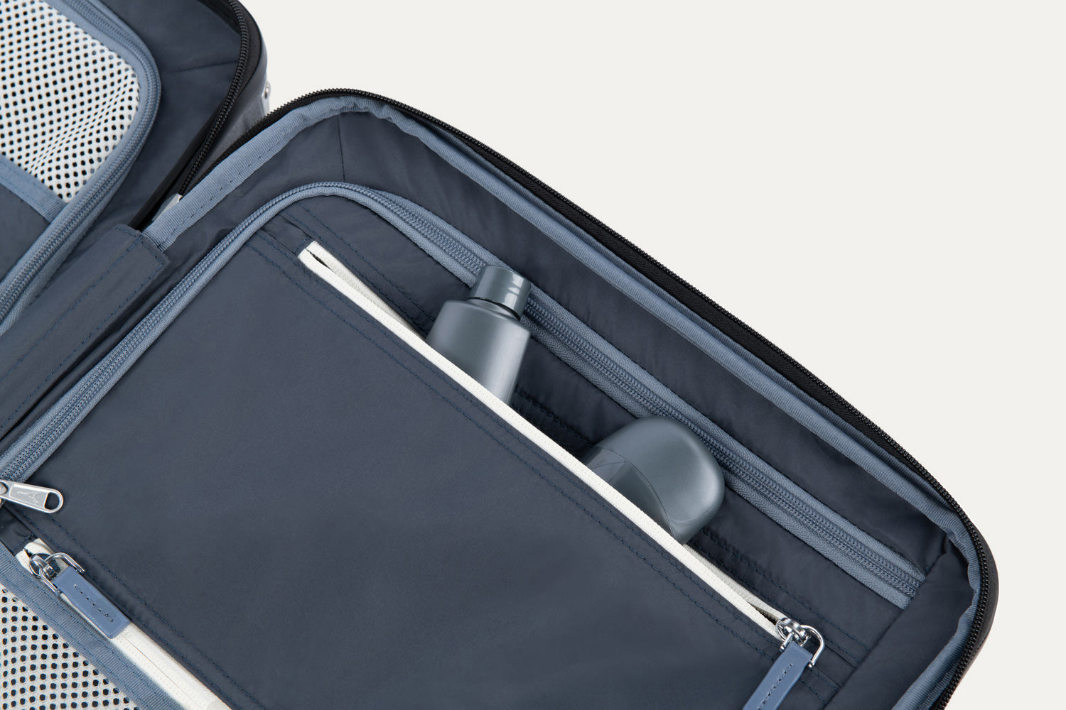 Open suitcase with essentials in  compartment on a white background