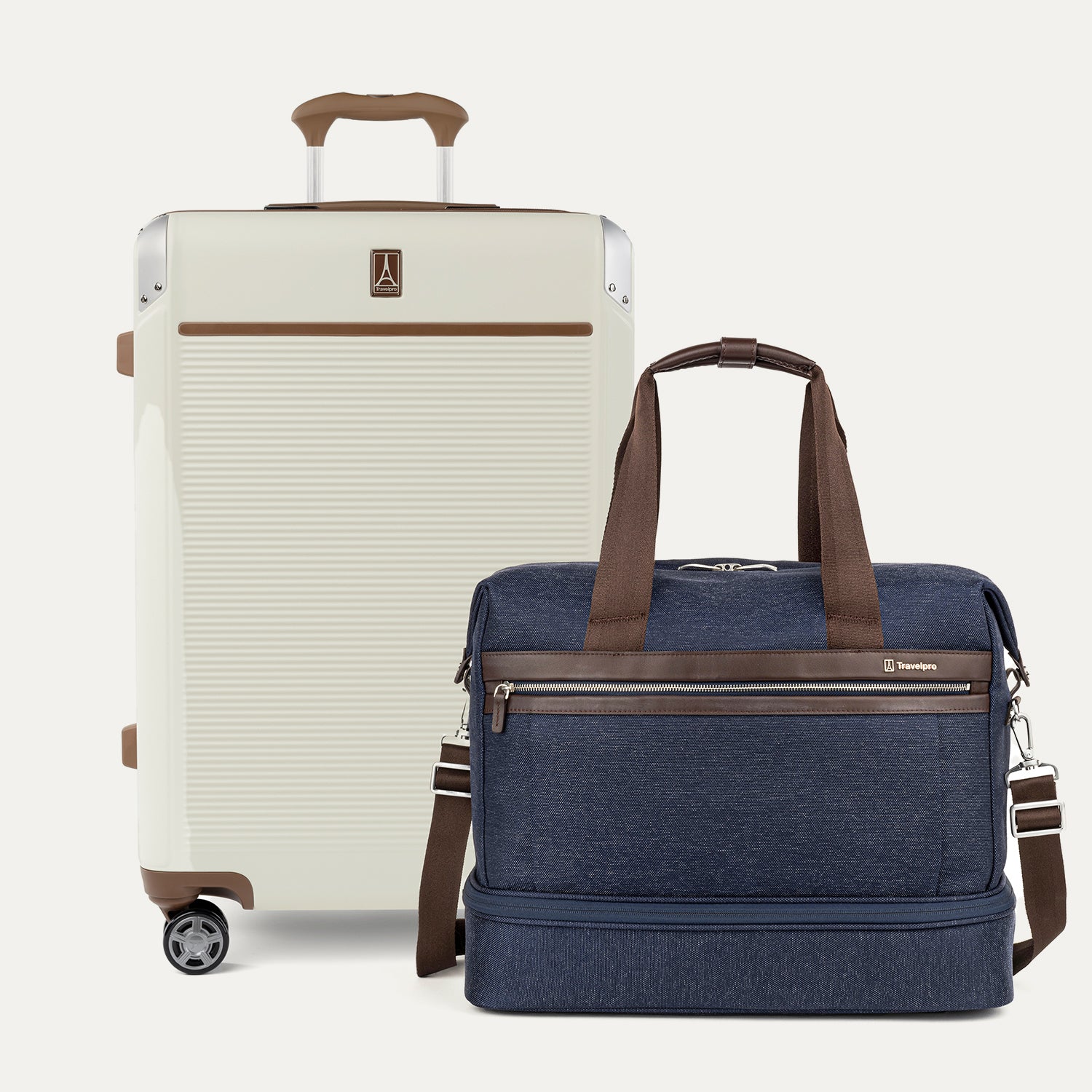 Beige suitcase and navy blue weekender with brown accents on a white background