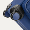 Close-up of a blue suitcase with black wheels on a white background