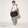 Person wearing a aviator navy duffel over the shoulder on a white background