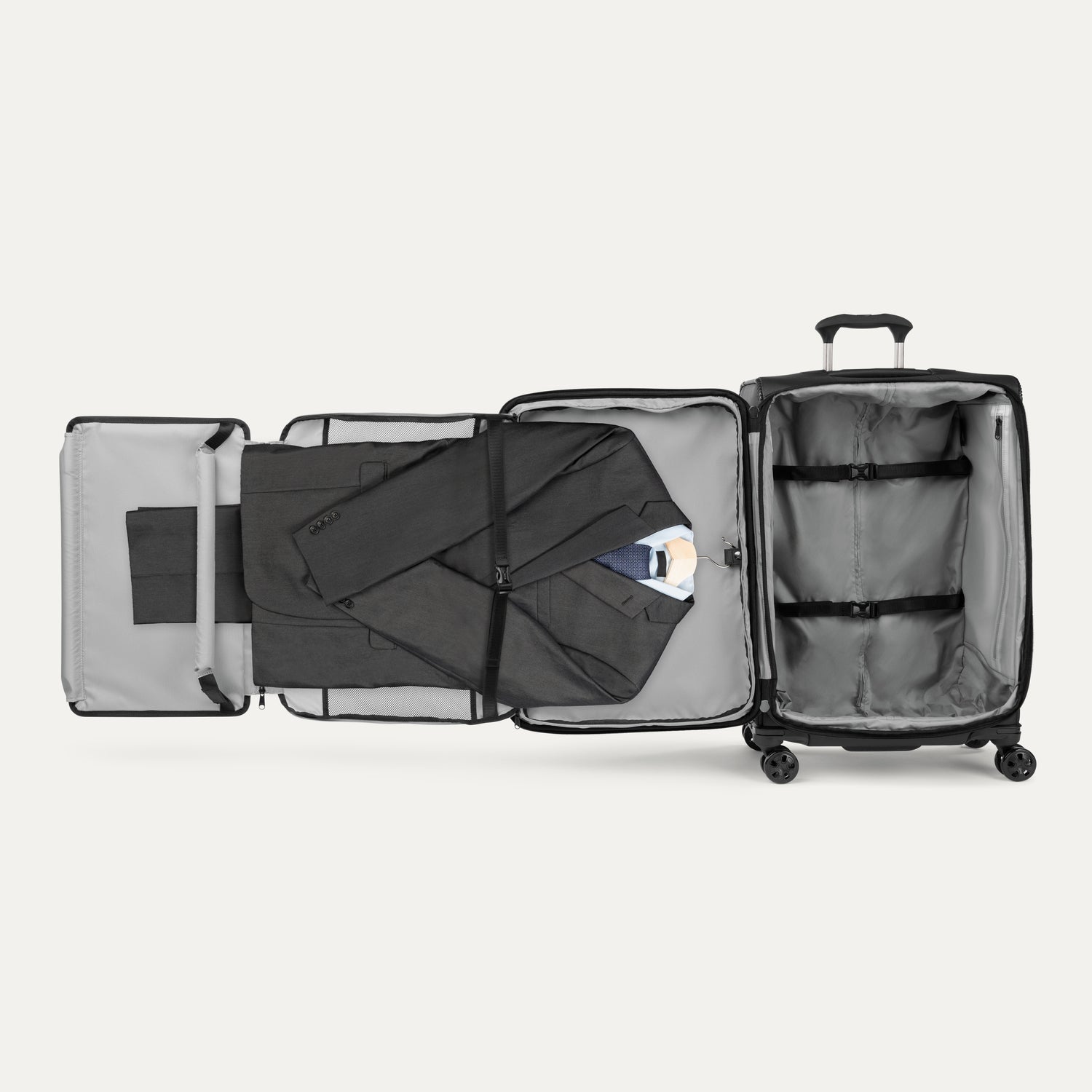 Open suitcase with suit displayed in fold out suiter compartment on white background