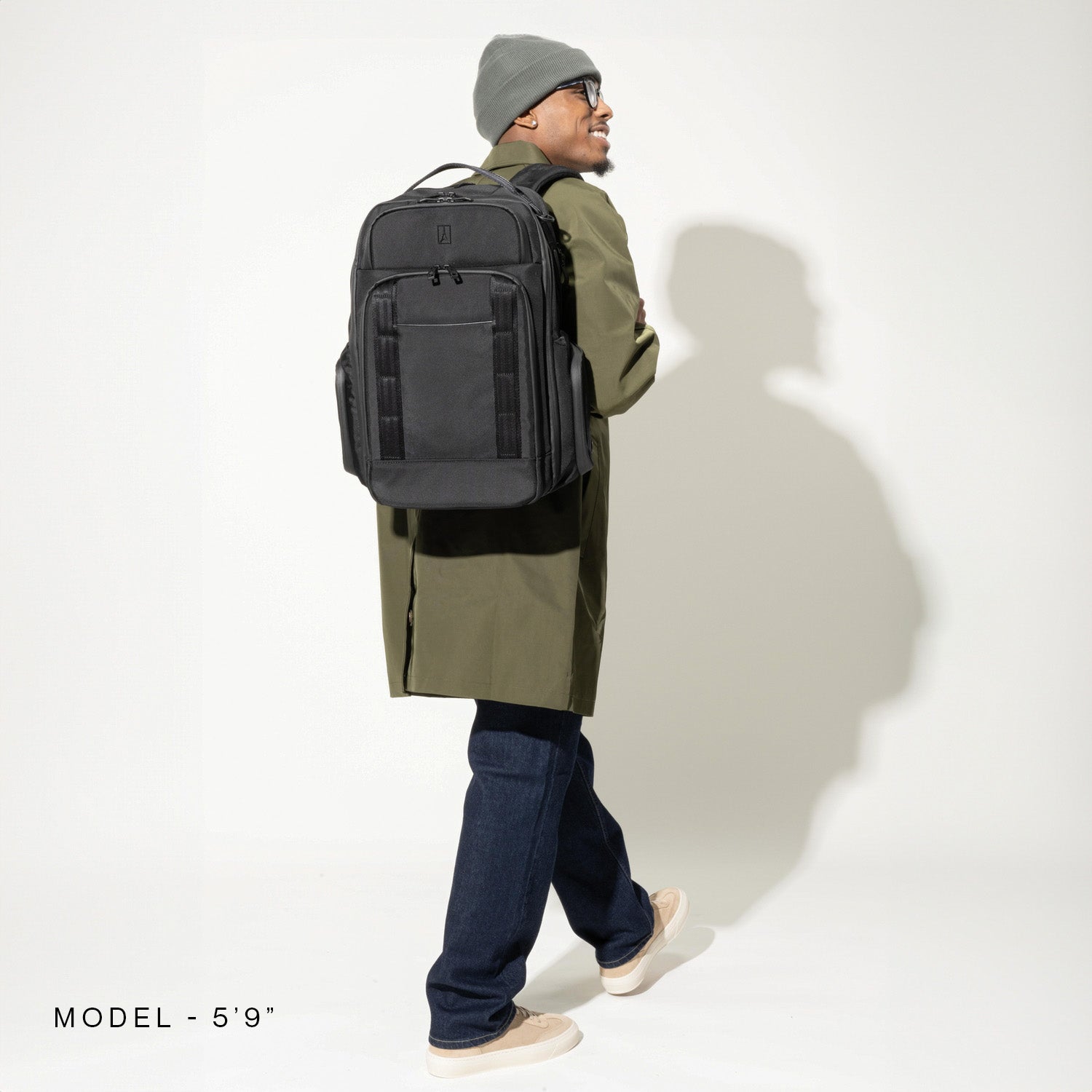 Person wearing a vintage black backpack on a white background