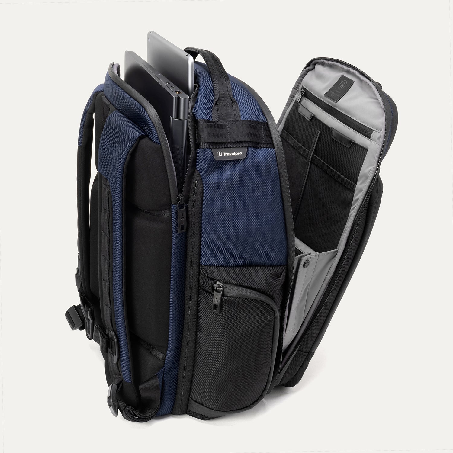 Aviator Navy backpack with open compartments, displaying laptop and tablet in their designated sleeves on a white background.