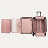 Pink suitcase with multiple compartments open on a white background