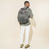 Person wearing a vintage grey business backpack on a white background